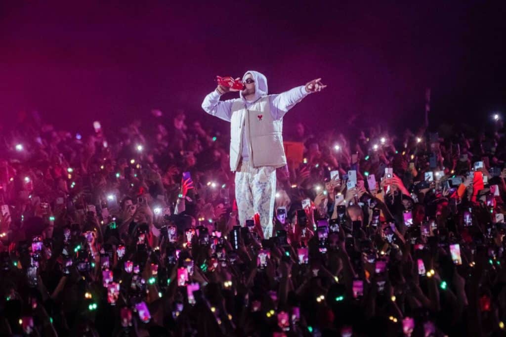 Image showing Bad Bunny performing at a live concert surrounded by fans