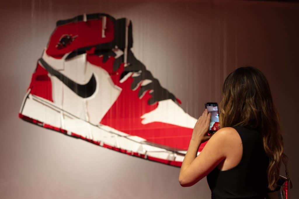 someone taking a picture of a Nike shoe artwork piece at Perceptual Experience: An Interactive Art Exhibition
