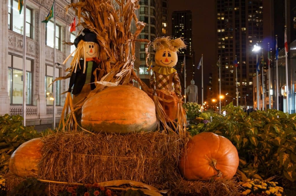 Scarecrows next to pumpkins and hay on Michigan Avenue during Halloween in Chicago, USA