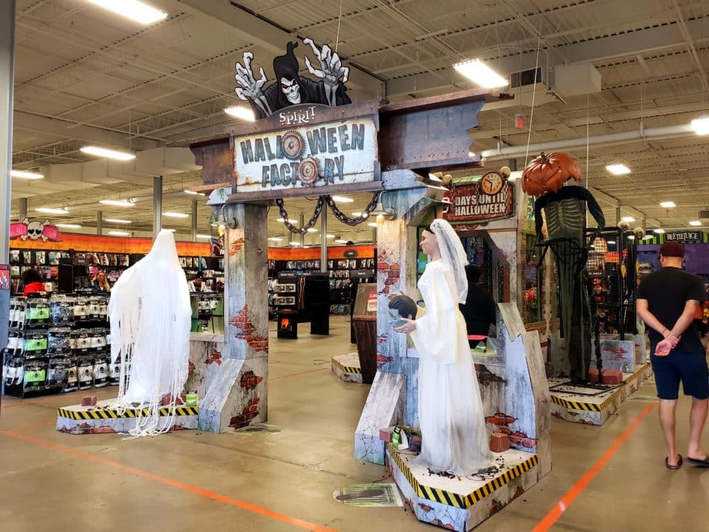 ghosts and a zombie bride next to a halloween spirit factory sign at Spirit Halloween Seasonal Store chicago