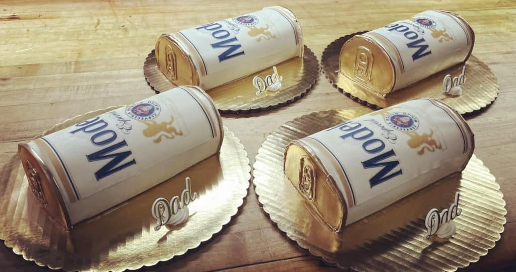 four modelo cakes with a white frosted cream label on gold plates from Roeser's Bakery