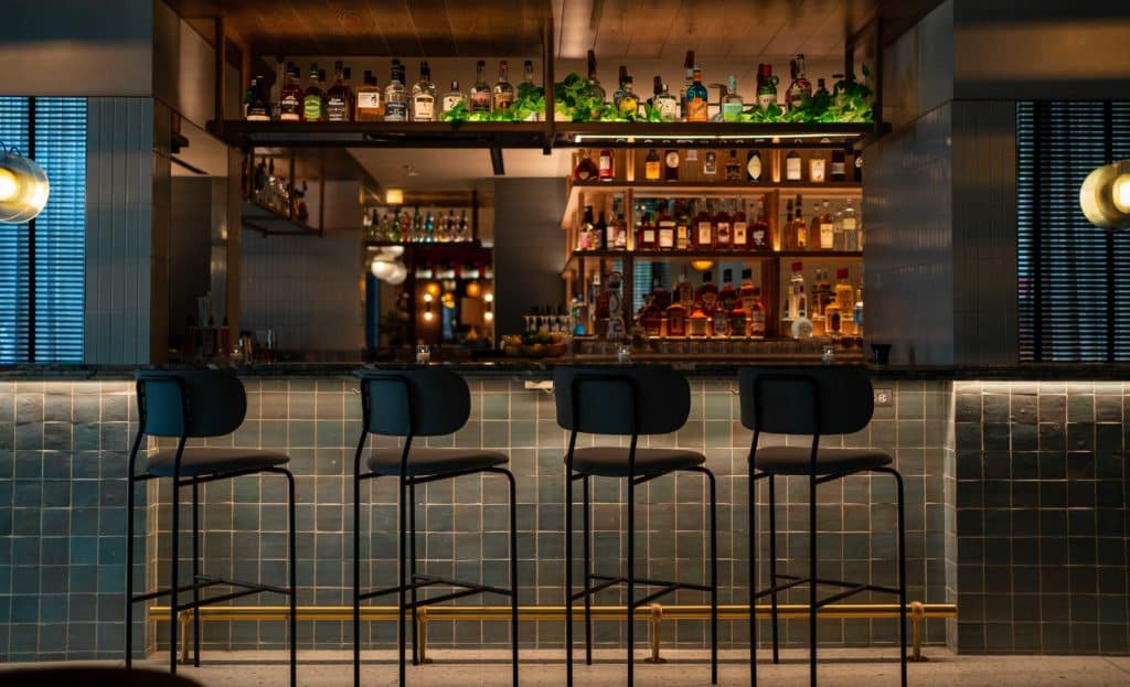 interior bar of lure fish bar with four stools and top shelf liquor