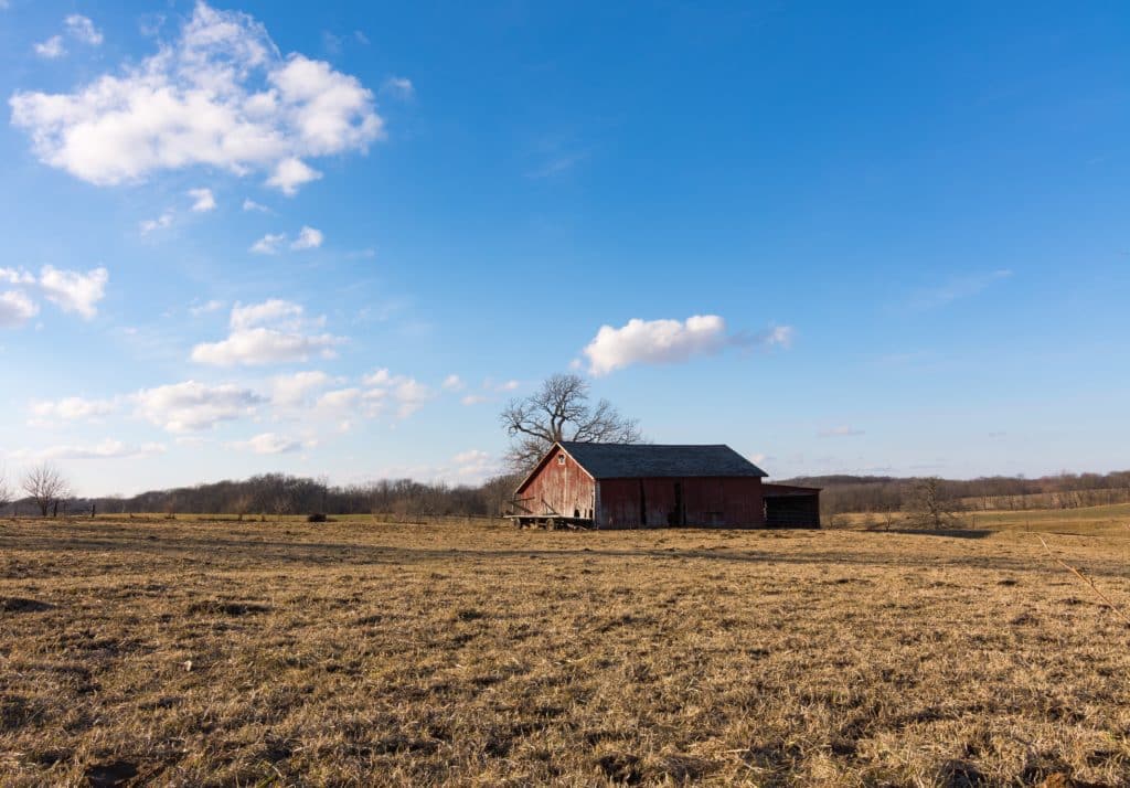 Old red barn in the open field. Putnam County, Illinois, USA